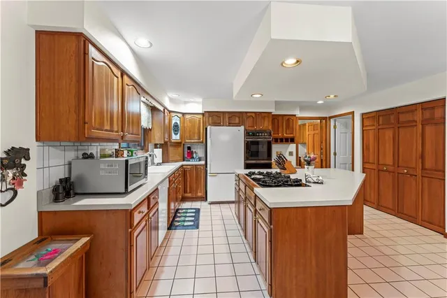 a kitchen with stainless steel appliances granite countertop a stove top oven a sink dishwasher and cabinets with wooden floor