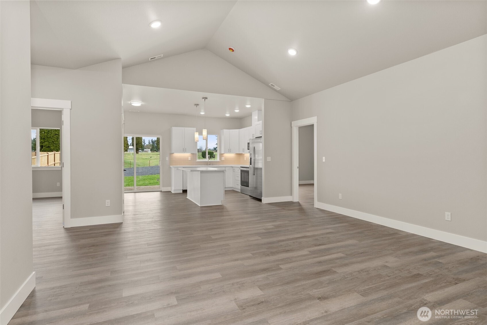 2103 Hawks Vw Lane Winlock, WA 98596 - Photo 2 of 24 an empty room with wooden floor and a kitchen