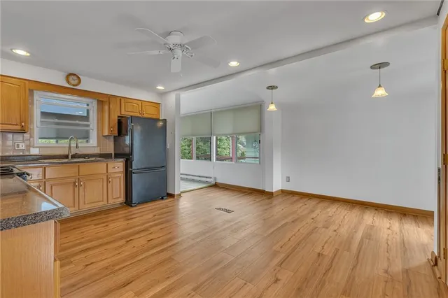 a view of kitchen with stainless steel appliances granite countertop a refrigerator and a sink