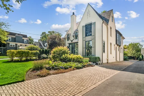 a front view of a house with a yard and potted plants