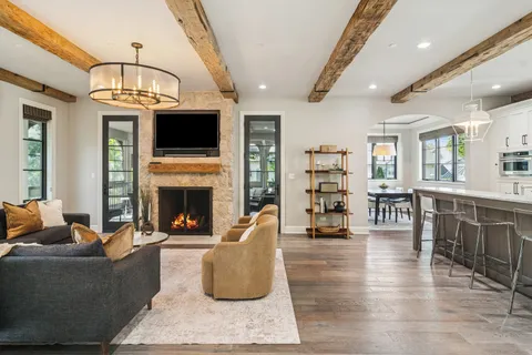a living room with furniture kitchen view and a chandelier