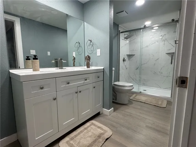 a bathroom with a double vanity sink toilet and shower