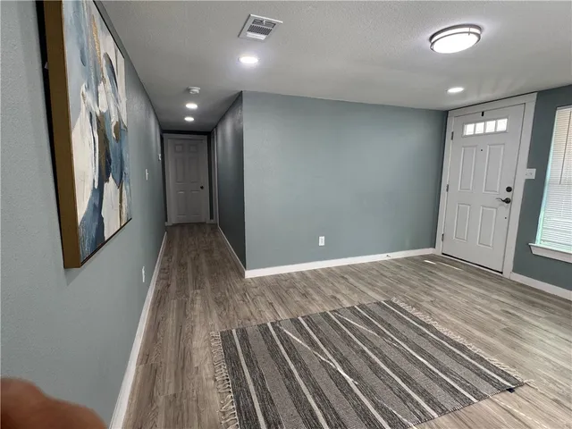 a view of a hallway with wooden floor