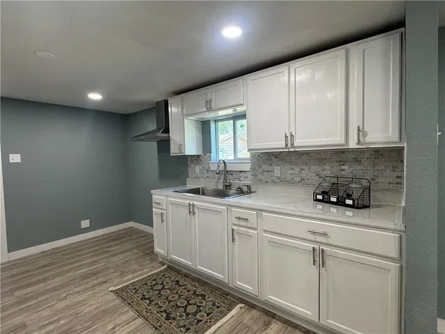 a kitchen with granite countertop white cabinets and white appliances