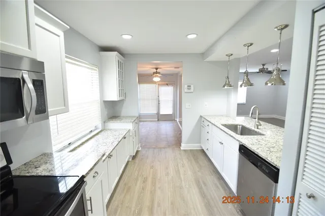 a large bathroom with a granite countertop double vanity sink a mirror and a bathtub