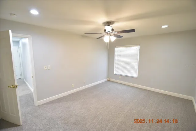 an empty room with windows and fan