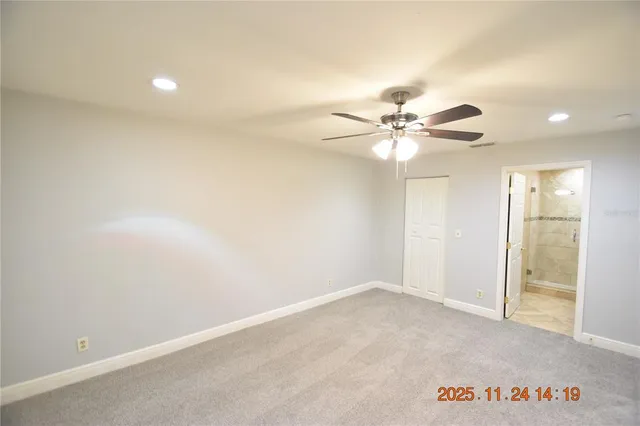 an empty room with a ceiling fan and a window