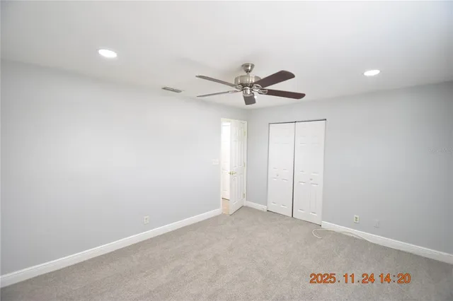 an empty room with a ceiling fan and a window