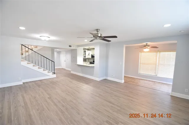 a view of an empty room with a window and wooden floor