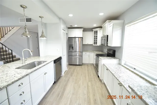a large kitchen with kitchen island granite countertop a large counter top and wooden floors