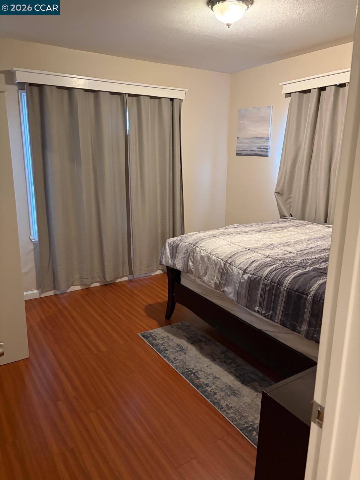 558 A Street Hayward, CA 94541 - Photo 7 of 9 a bedroom with a bed and a mirror