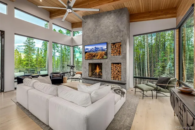 a living room with furniture a fireplace and a large window