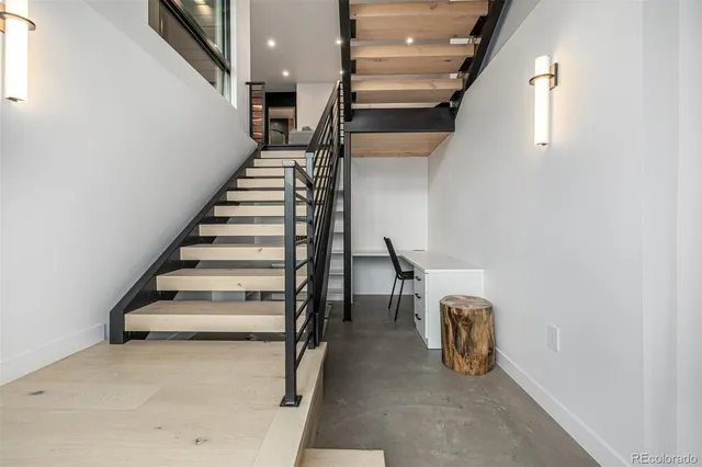 a large white kitchen with a stove a refrigerator a sink and dishwasher with wooden floor