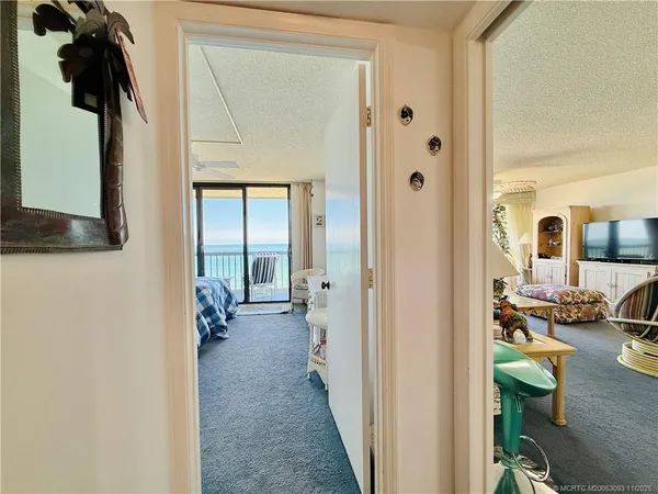 a living room with stainless steel appliances kitchen island granite countertop furniture and a flat screen tv