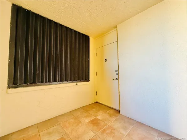 a kitchen that has a lot of white cabinets and wooden floor
