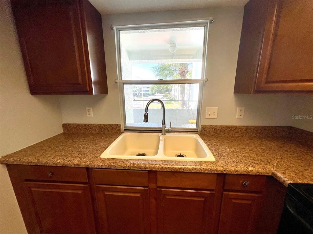2579 Countryside Boulevard, Unit 203 Clearwater, FL 33761 - Photo 29 of 37 a kitchen with sink a window and cabinets