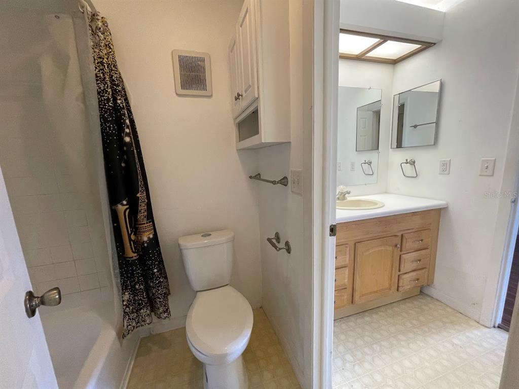 2579 Countryside Boulevard, Unit 203 Clearwater, FL 33761 - Photo 32 of 37 a bathroom with a sink toilet and mirror