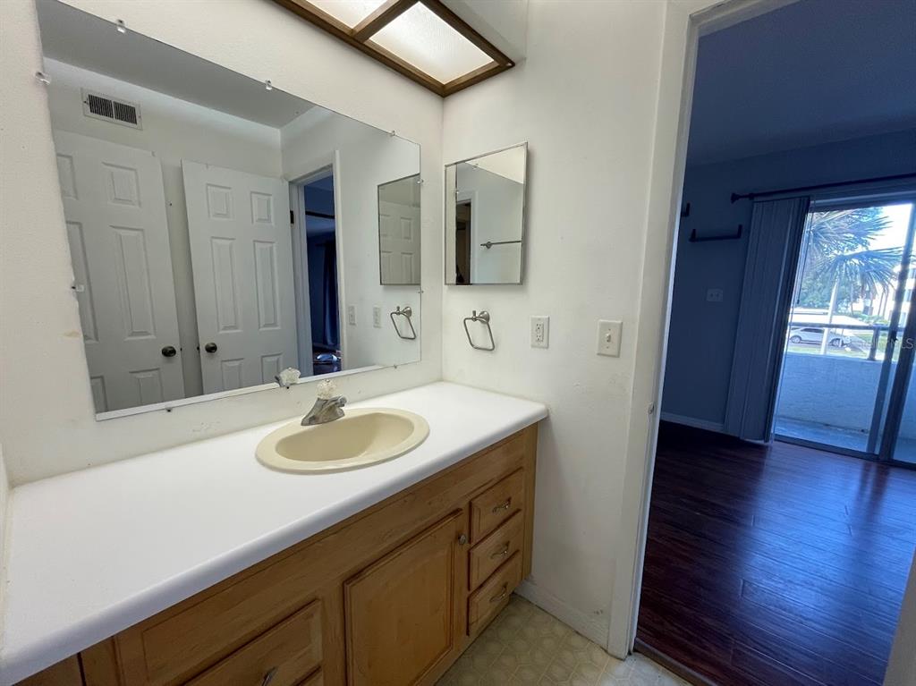 2579 Countryside Boulevard, Unit 203 Clearwater, FL 33761 - Photo 34 of 37 a bathroom with a granite countertop sink and a mirror