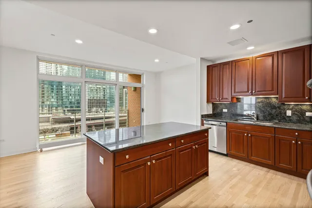 a kitchen with stainless steel appliances granite countertop wooden cabinets a sink and dishwasher