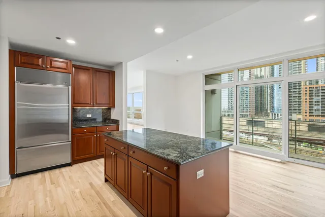a kitchen with stainless steel appliances granite countertop a refrigerator and a sink