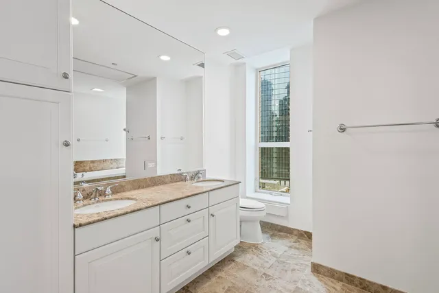 a spacious bathroom with a granite countertop sink mirror and a toilet