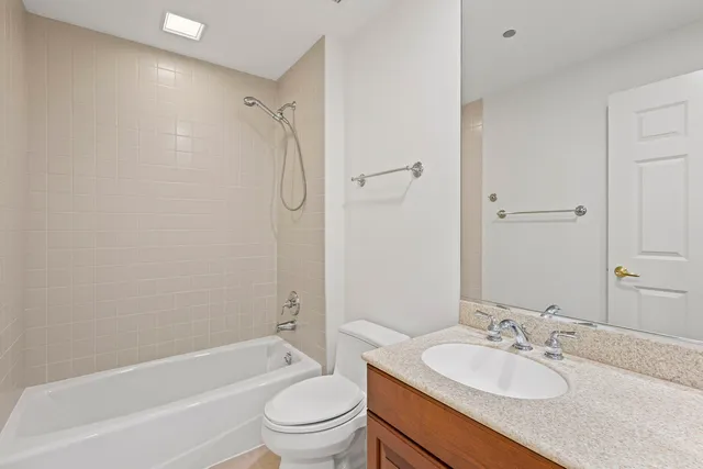 a bathroom with a granite countertop sink toilet mirror and shower