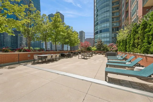 a view of a patio with a bench and trees