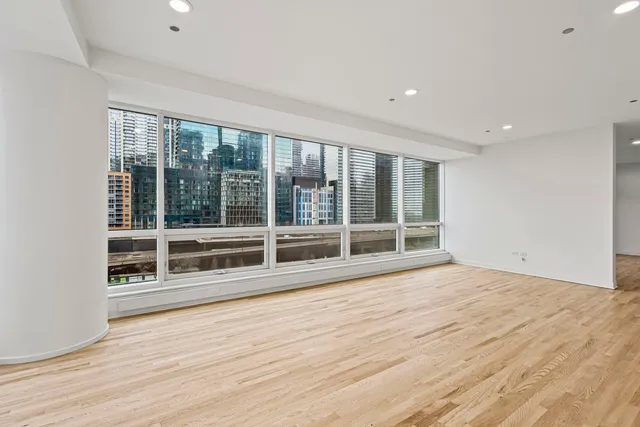 a view of empty room with wooden floor and windows