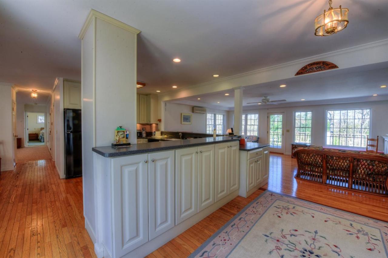 923 Old Post Road Cotuit, MA 02635 - Photo 8 of 35 a kitchen with stainless steel appliances granite countertop a refrigerator a sink dishwasher a stove and a dining table with wooden floor