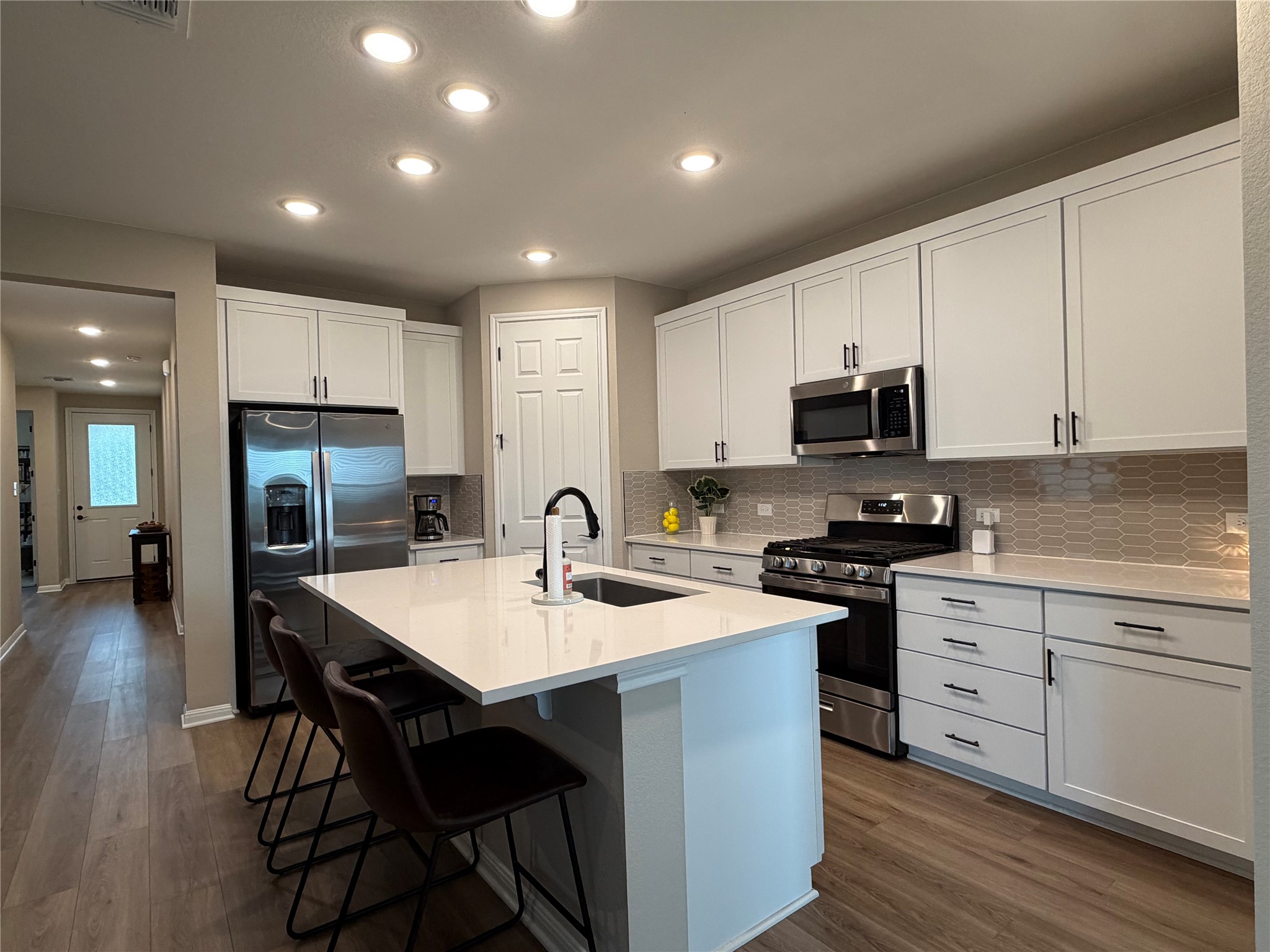 549 Raleigh Drive Georgetown, TX 78633 - Photo 24 of 29 a kitchen with stainless steel appliances granite countertop a table chairs sink refrigerator and cabinets