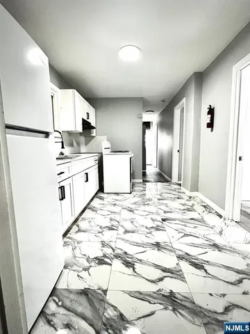 a large white kitchen with kitchen island a stove a sink and a refrigerator