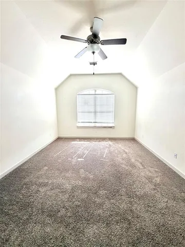 an empty room with a ceiling fan and window