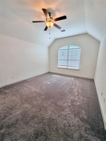 an empty room with a window and a ceiling fan