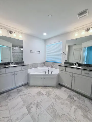 a large bathroom with a large tub and double vanity