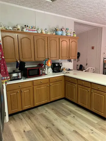 a large kitchen with stainless steel appliances wooden cabinets and a stove top oven