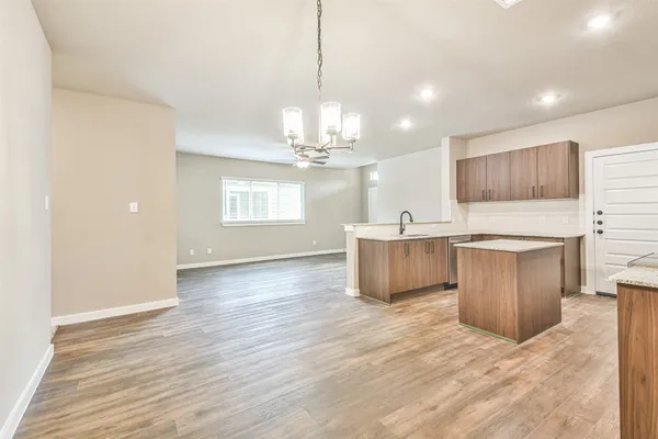 a large kitchen with kitchen island granite countertop a sink cabinets and wooden floor