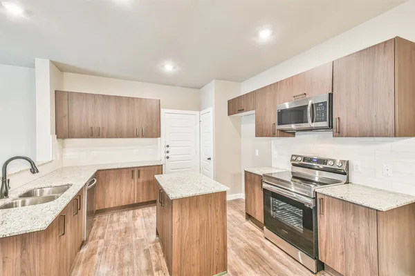 a kitchen with granite countertop a stove and a sink