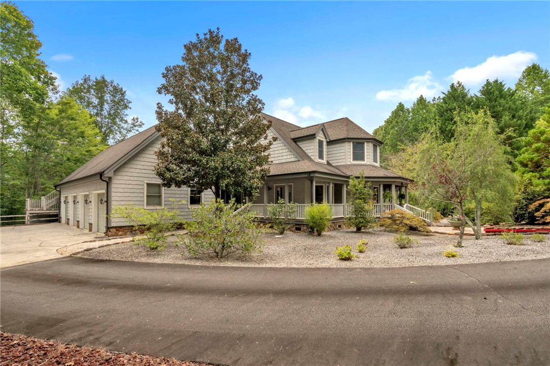 This grand residence showcases traditional architecture with a broad front porch and attached garage.