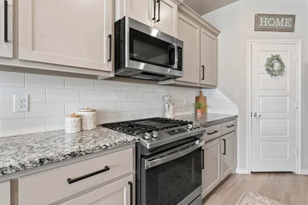 a kitchen with stainless steel appliances granite countertop a stove and a microwave