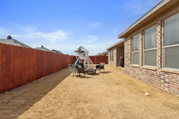 a view of a backyard with table and chairs