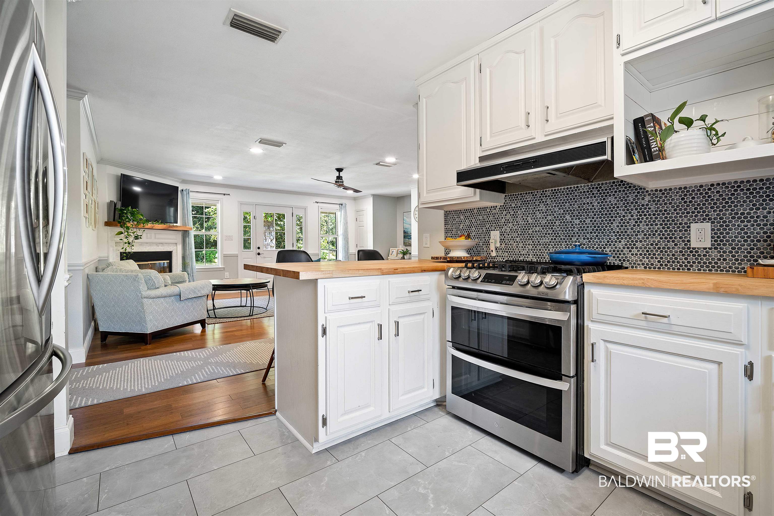808 Michigan Avenue Fairhope, AL 36532 - Photo 9 of 33 Kitchen featuring white cabinets, kitchen peninsula, butcher block countertops, stainless steel appliances, and light hardwood / wood-style floors