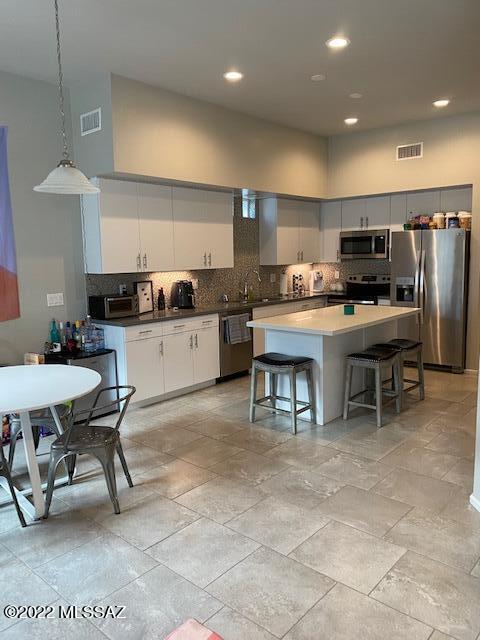 866 East Millenium Court Tucson, AZ 85719 - Photo 8 of 15 a kitchen with stainless steel appliances kitchen island granite countertop a sink and a refrigerator