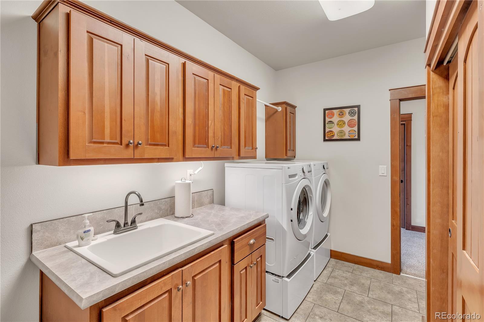 6839 Estes Drive Arvada, CO 80004 - Photo 17 of 34 a utility room with sink dryer and washer