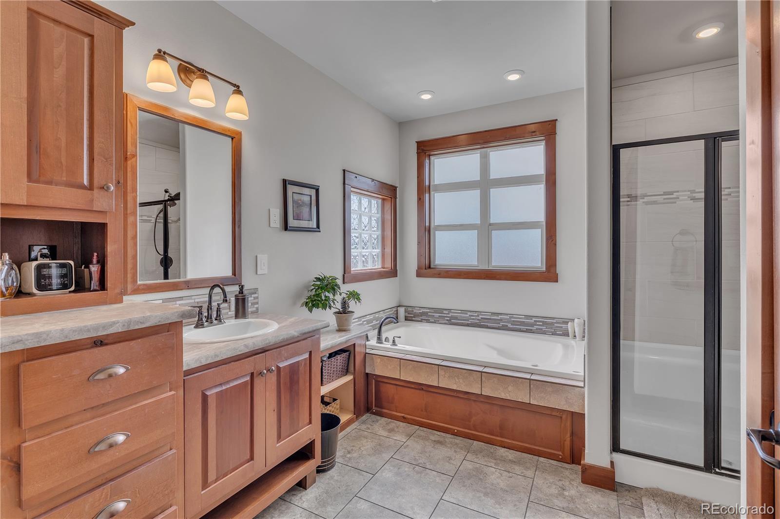 6839 Estes Drive Arvada, CO 80004 - Photo 21 of 34 a spacious bathroom with a tub sink and mirror