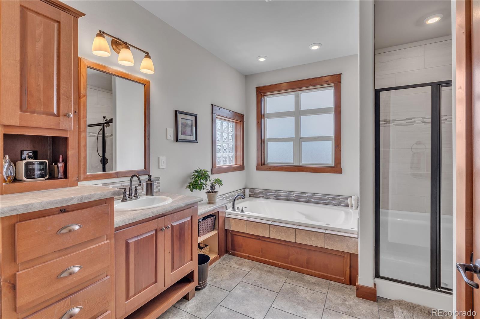6839 Estes Drive Arvada, CO 80004 - Photo 22 of 34 a spacious bathroom with a tub sink and mirror