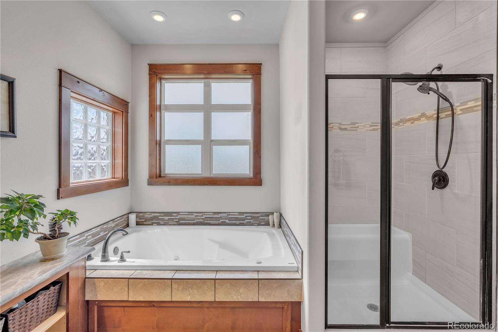 6839 Estes Drive Arvada, CO 80004 - Photo 23 of 34 a bathroom with a tub a sink and a window