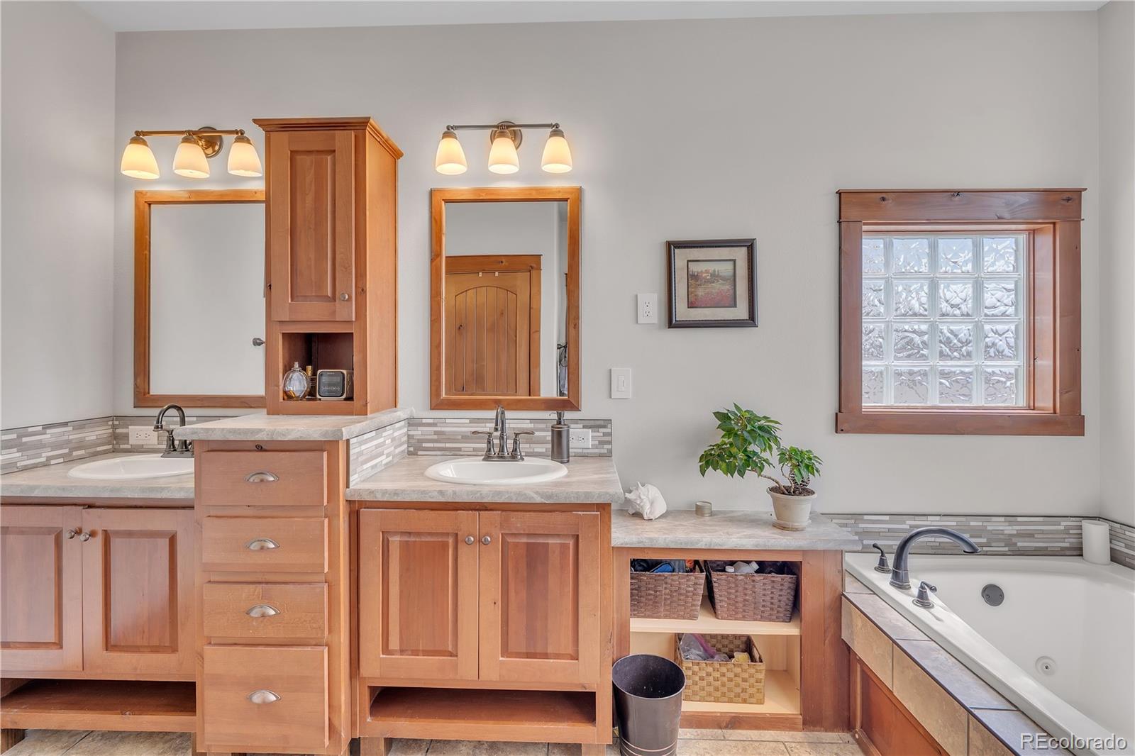 6839 Estes Drive Arvada, CO 80004 - Photo 24 of 34 a spacious bathroom with a granite countertop sink and a mirror