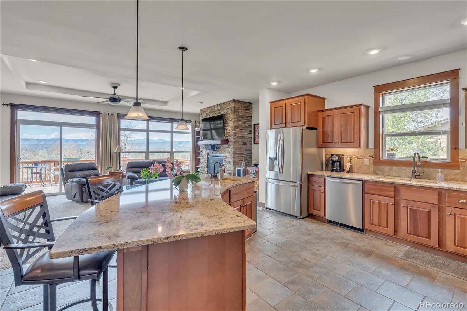 6839 Estes Drive Arvada, CO 80004 - Photo 7 of 34 a kitchen with stainless steel appliances granite countertop a refrigerator a sink a stove and island