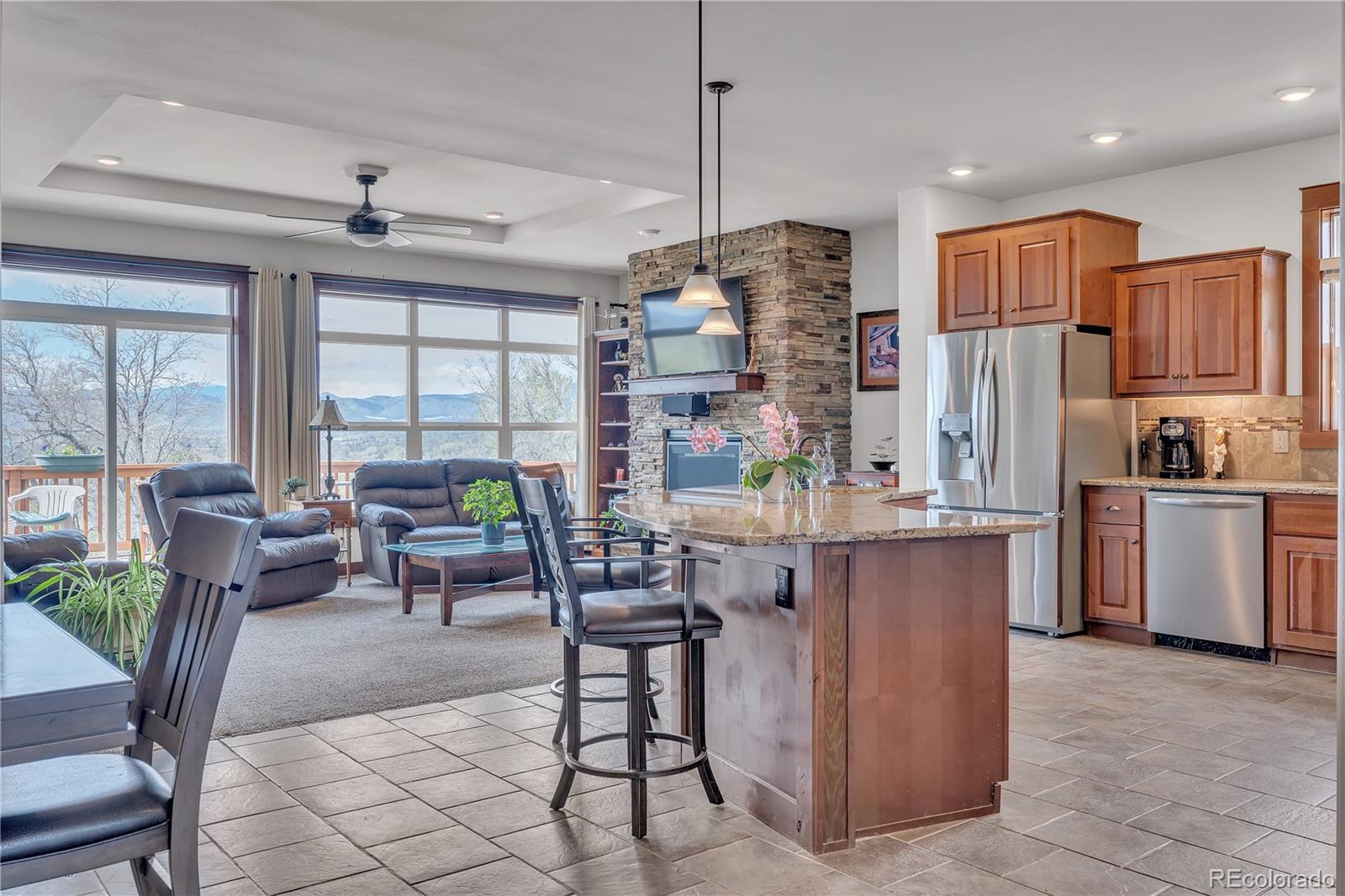 6839 Estes Drive Arvada, CO 80004 - Photo 8 of 34 a kitchen with stainless steel appliances granite countertop a refrigerator a stove a sink a dining table and chairs with wooden floor