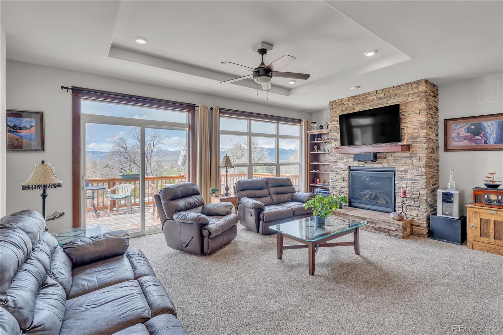6839 Estes Drive Arvada, CO 80004 - Photo 9 of 34 a living room with furniture a flat screen tv and a fireplace